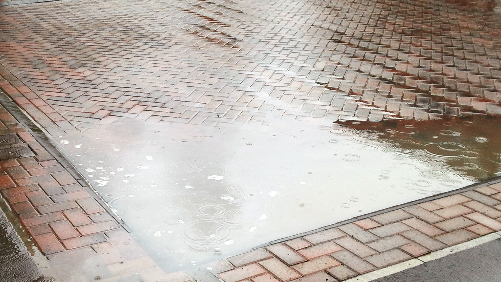 block paved driveway with bad drainage and flooding