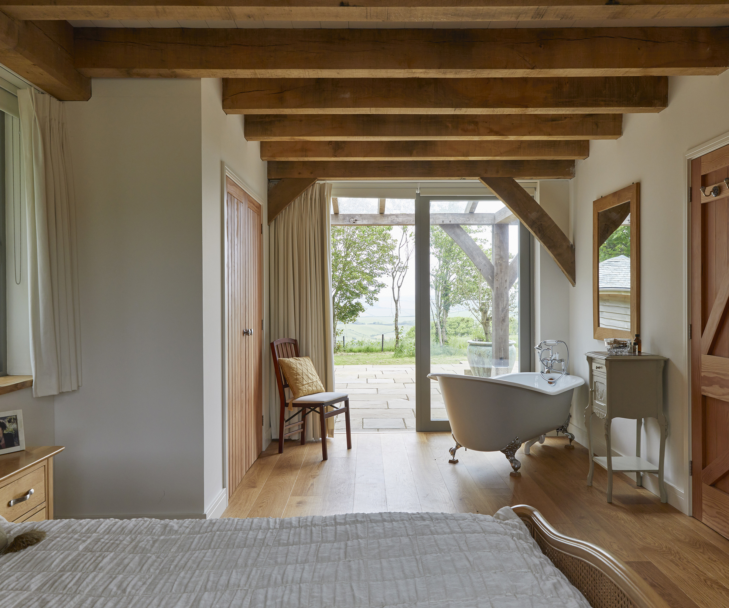 Double bedroom with free standing bath with view out to a stone patio