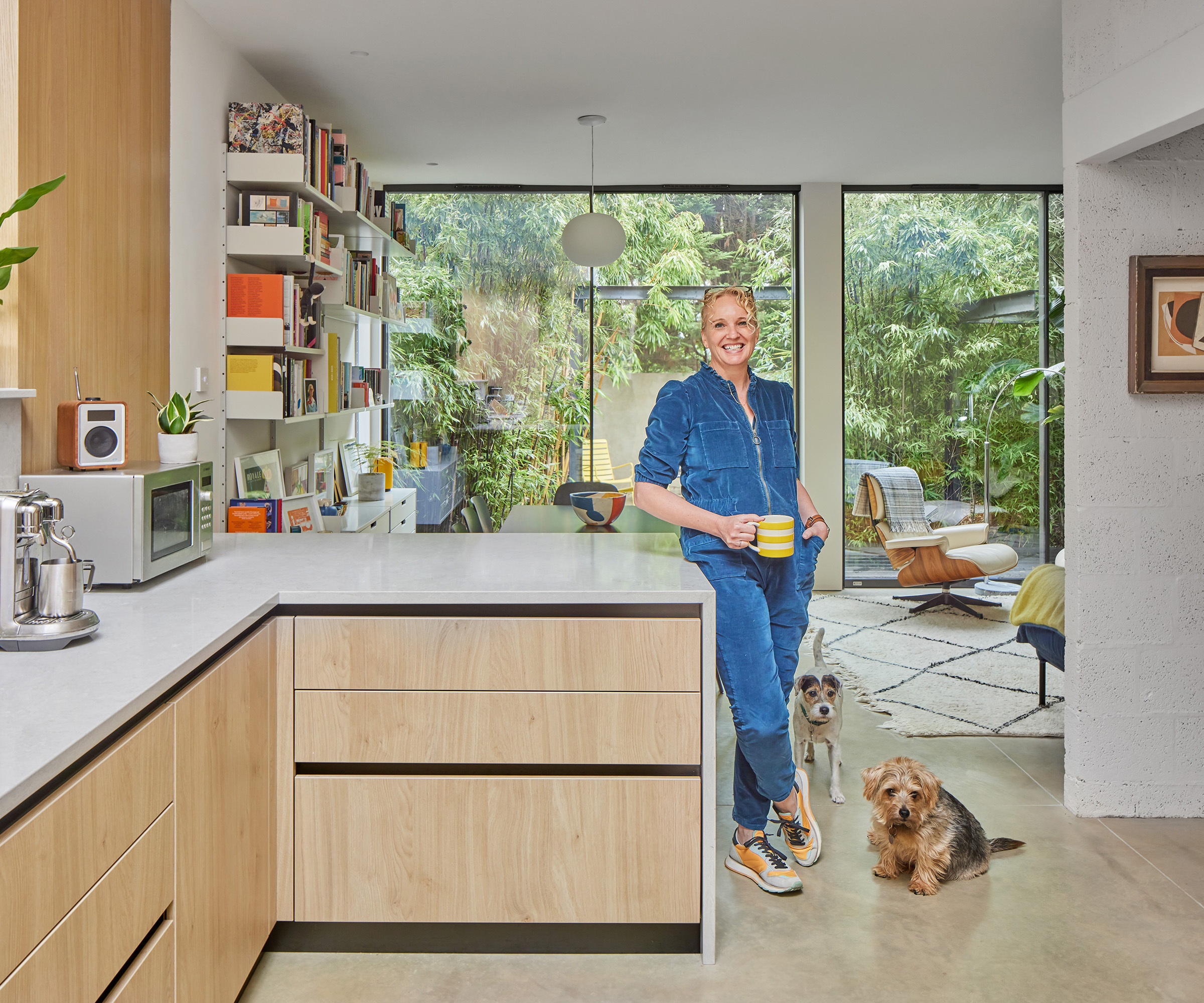 Woman home owner standing at a kitchen counter with large glazed doors in the background